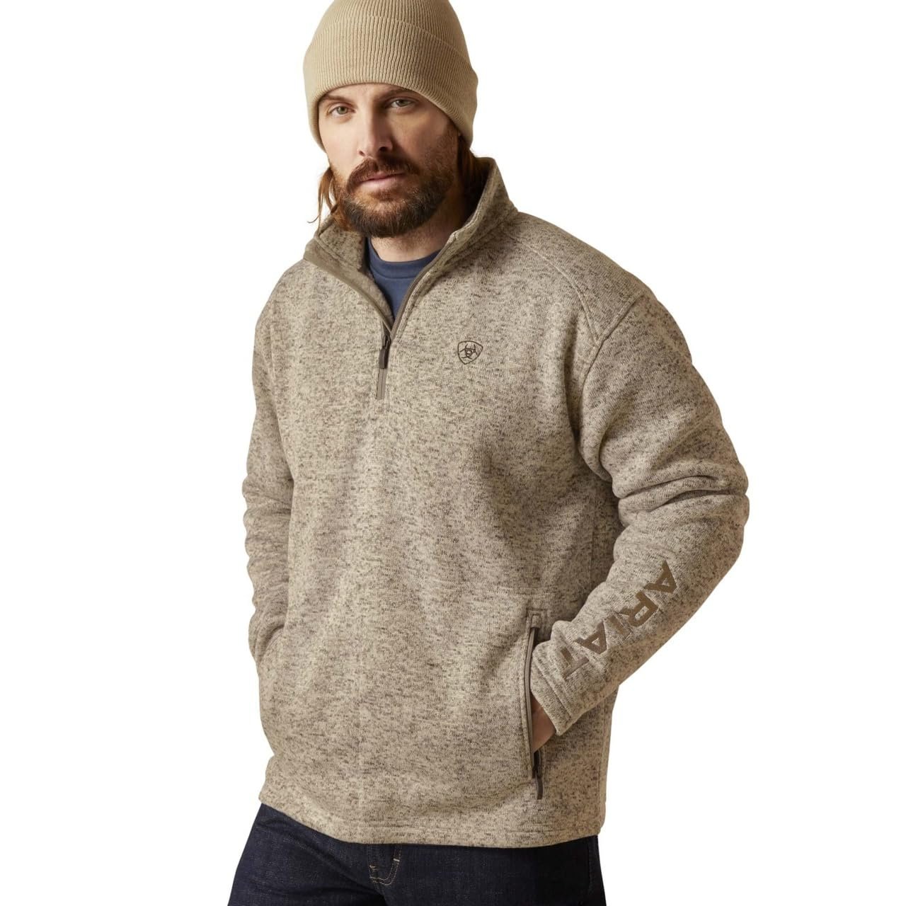 Man wearing a beige fleece pullover and beanie on a white background