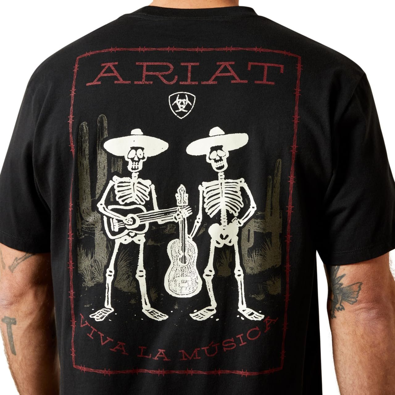Black t-shirt with skeleton design and 'Ariat' branding on a white background