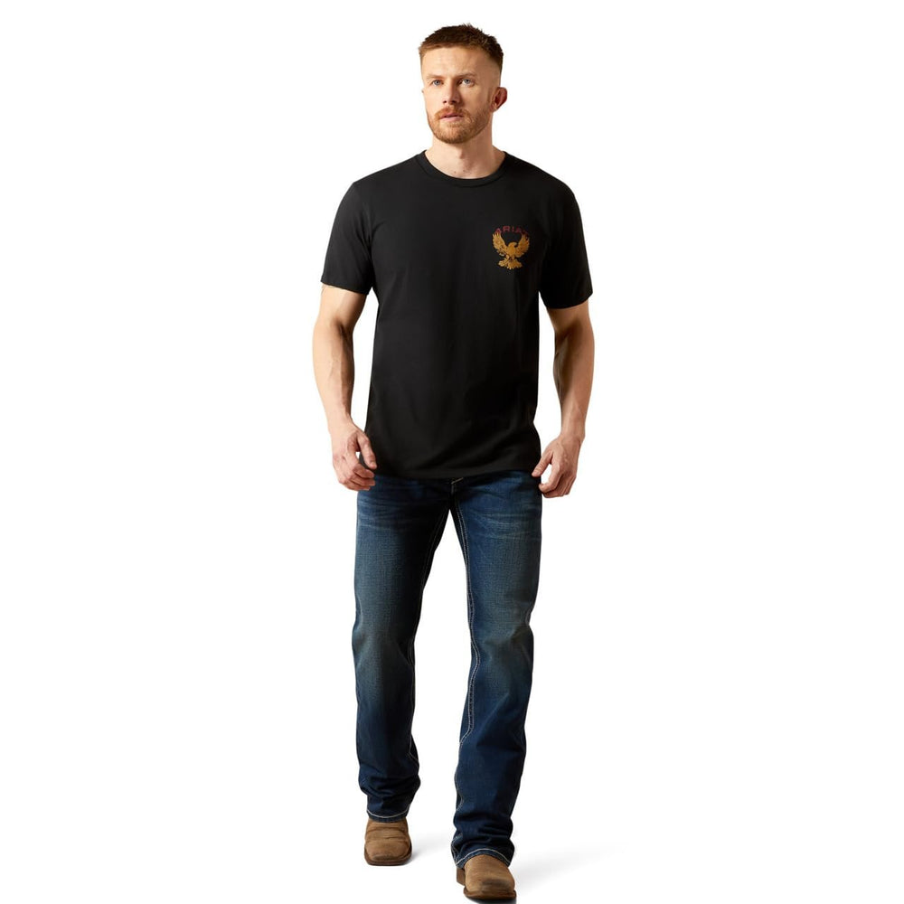 
                  
                    Man wearing a black t-shirt with a logo and blue jeans on a white background
                  
                