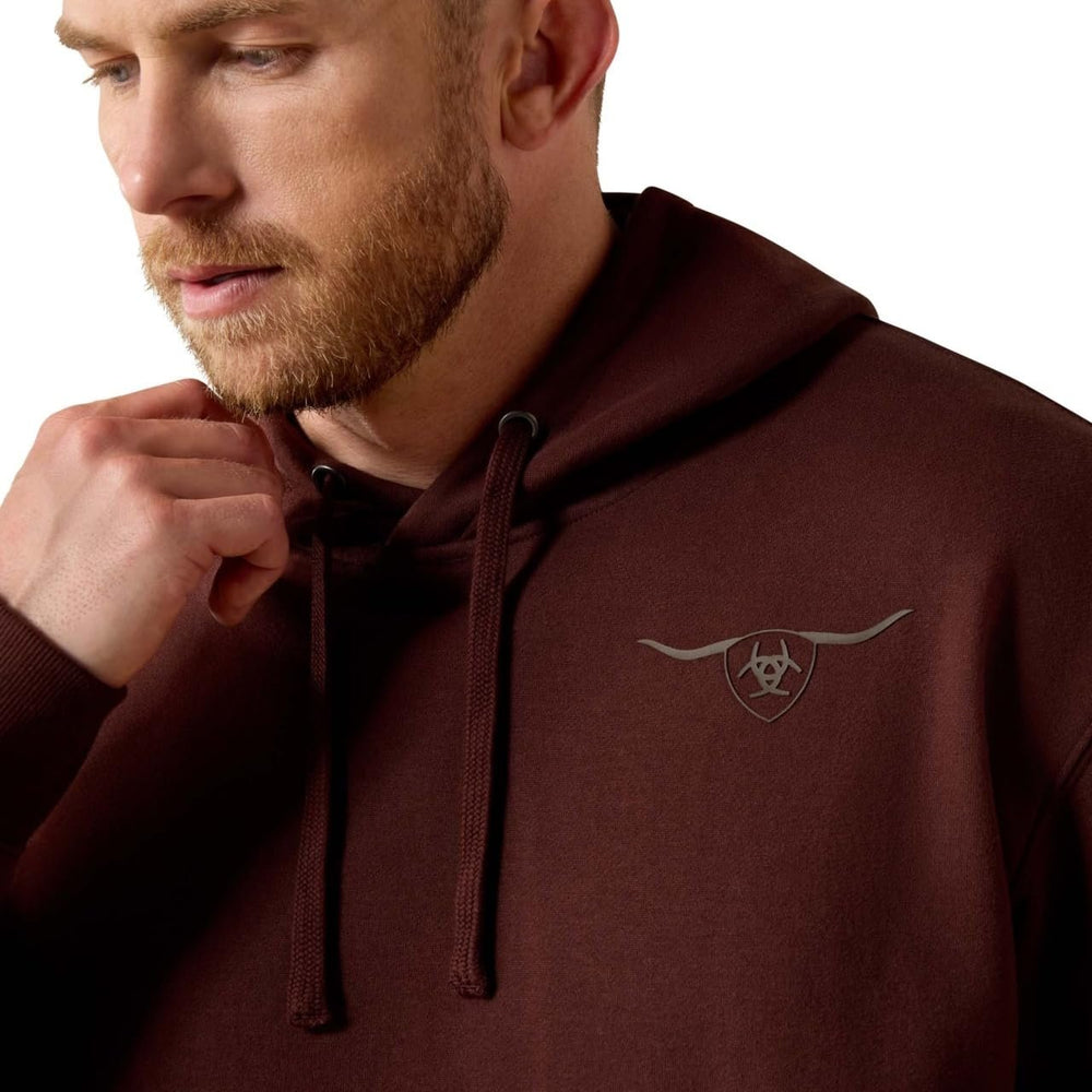 
                  
                    Man wearing a maroon hoodie with a logo on the chest against a white background
                  
                