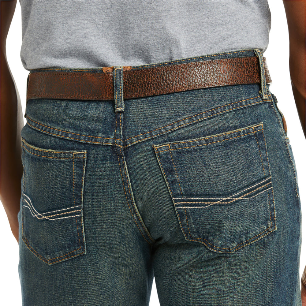 
                  
                    Close-up of blue jeans with a brown belt on a white background
                  
                