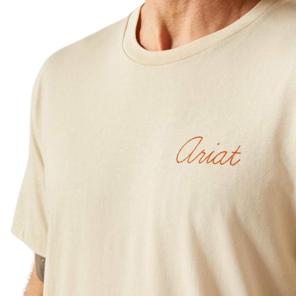 
                  
                    Beige t-shirt with 'Ariat' logo on a plain background
                  
                