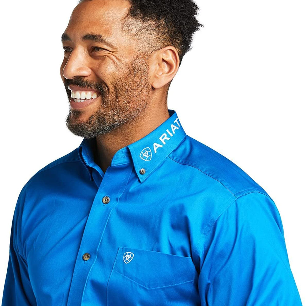 
                  
                    Man wearing a blue Ariat shirt on a white background
                  
                