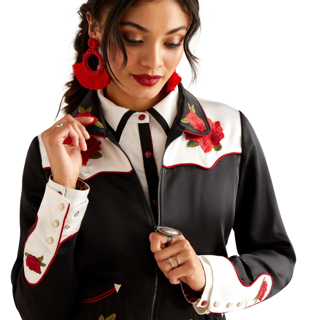 Woman wearing a black and white jacket with red floral embroidery on a white background