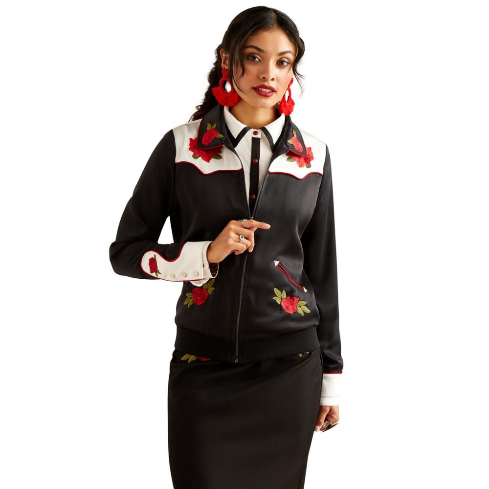 Woman wearing a black and white outfit with floral embroidery on a white background