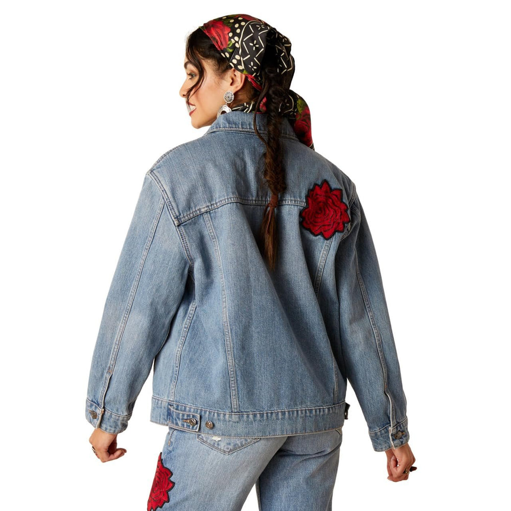 
                  
                    Person wearing a denim jacket with red floral patches on a white background
                  
                