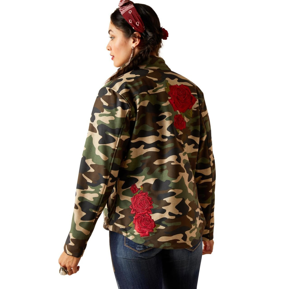 Camouflage jacket with red floral patches worn by a person on a white background