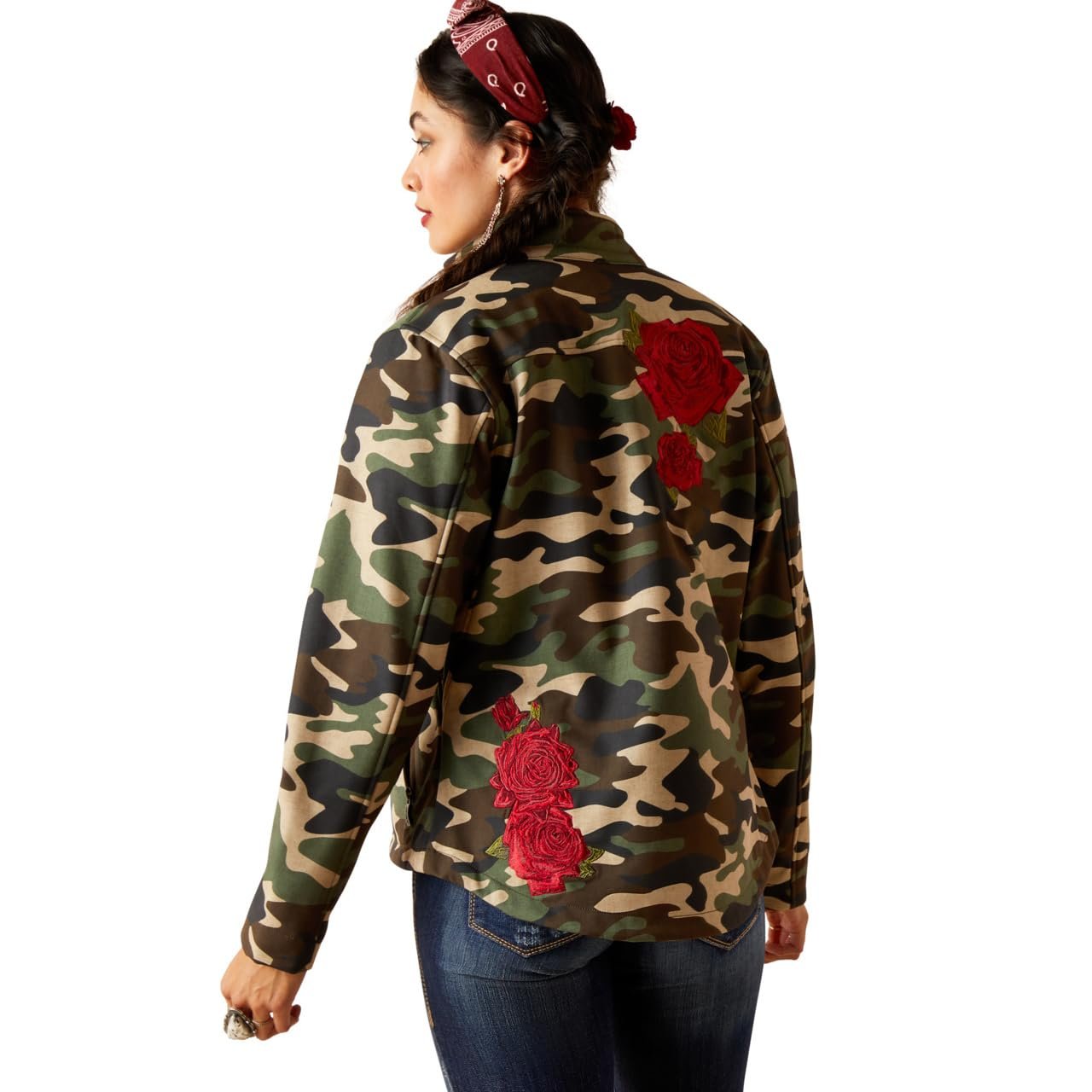 Camouflage jacket with red floral patches worn by a person on a white background