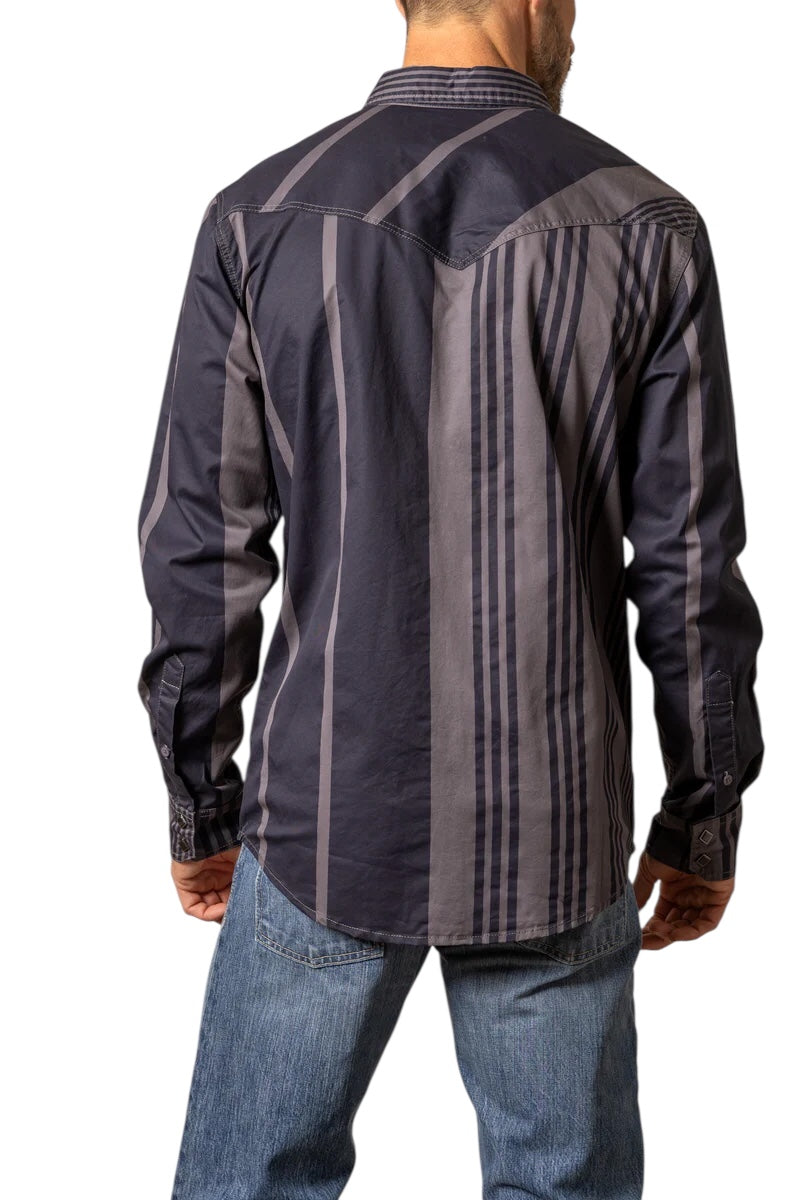 Man wearing a dark patterned shirt and jeans on a white background