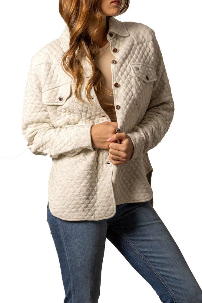 
                  
                    Woman wearing a beige quilted jacket and blue jeans on a white background
                  
                