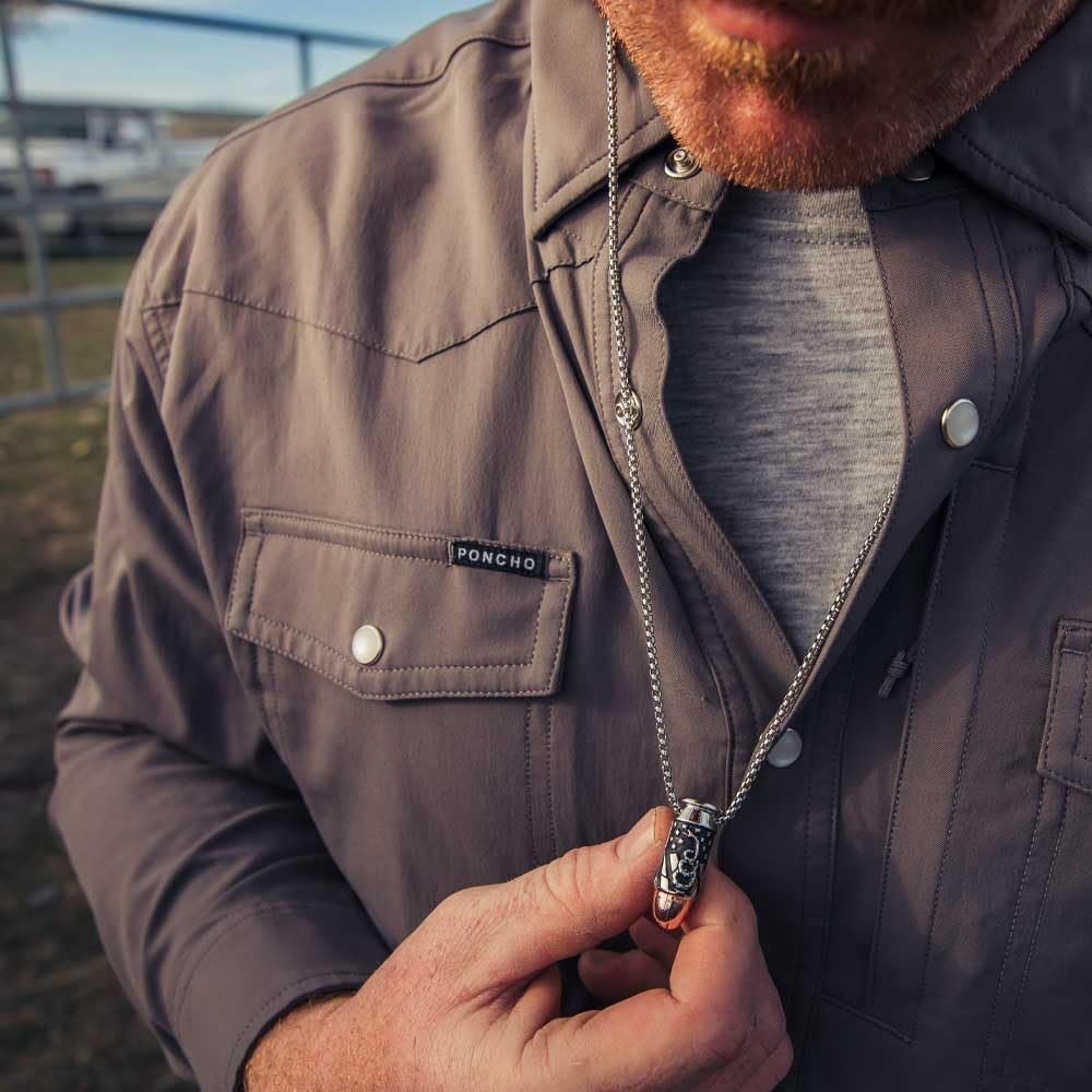 
                  
                    Man wearing a brown jacket with a visible brand logo, holding a necklace.
                  
                