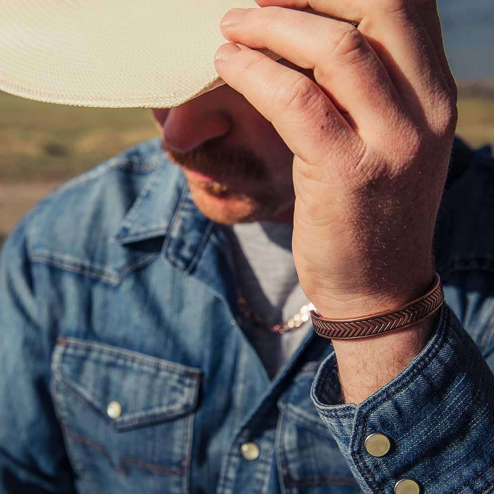 
                  
                    Person wearing a denim jacket and a bracelet, with a blurred background
                  
                