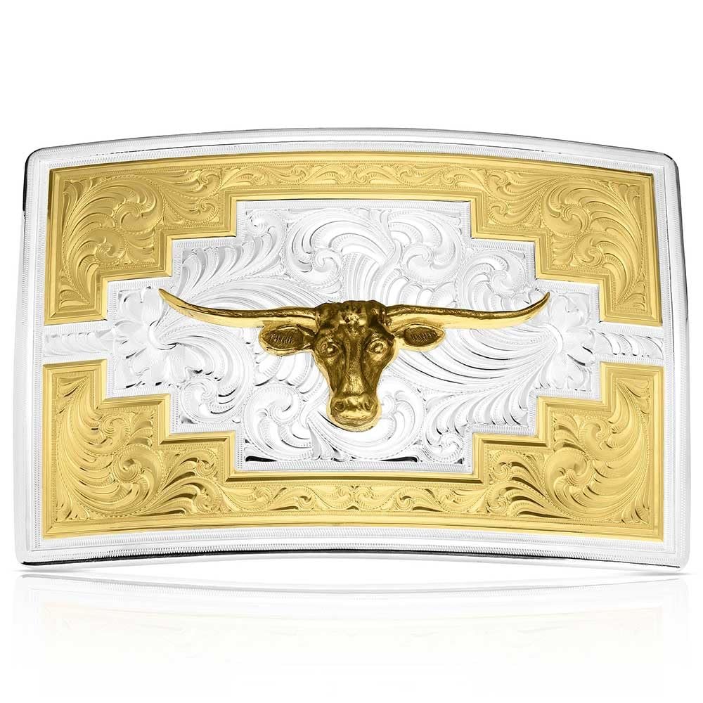 Gold and silver belt buckle with bull design on a white background