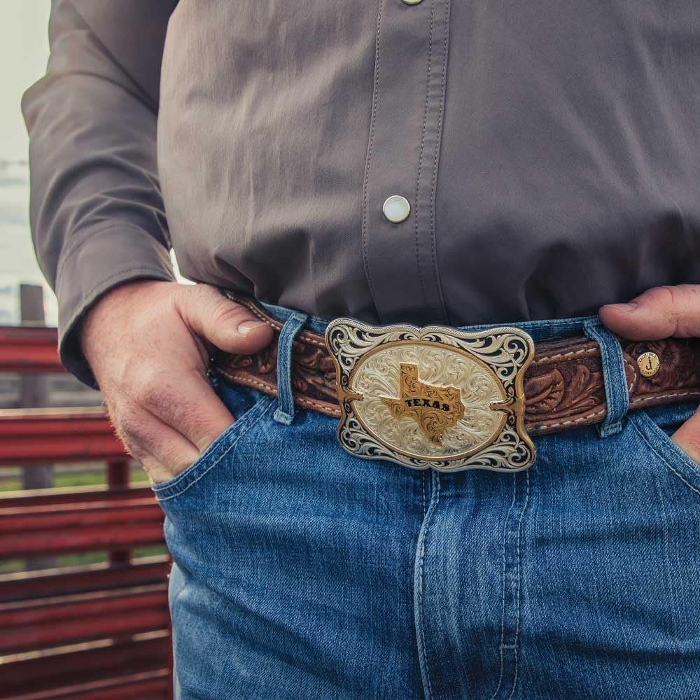 Person wearing a belt with a Texas buckle in an outdoor setting