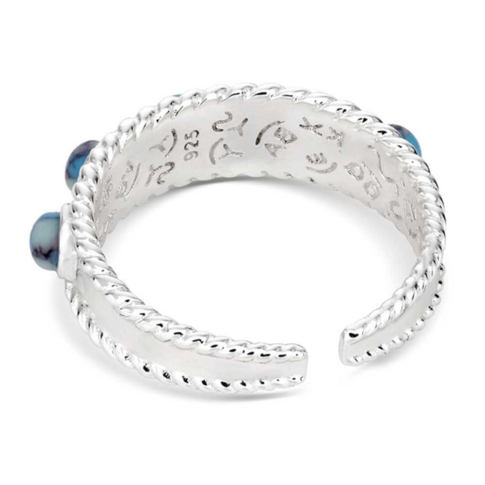 
                  
                    Silver ring with blue gemstones on a white background
                  
                