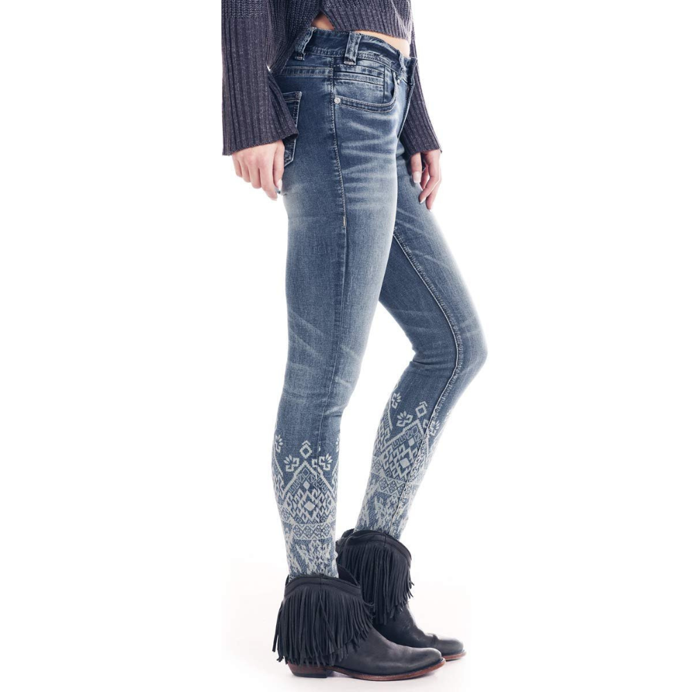 Person wearing blue jeans with a pattern and fringed boots on a white background