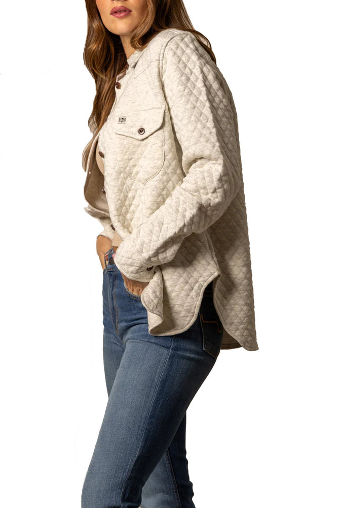 
                  
                    Person wearing a beige quilted jacket and blue jeans on a white background
                  
                