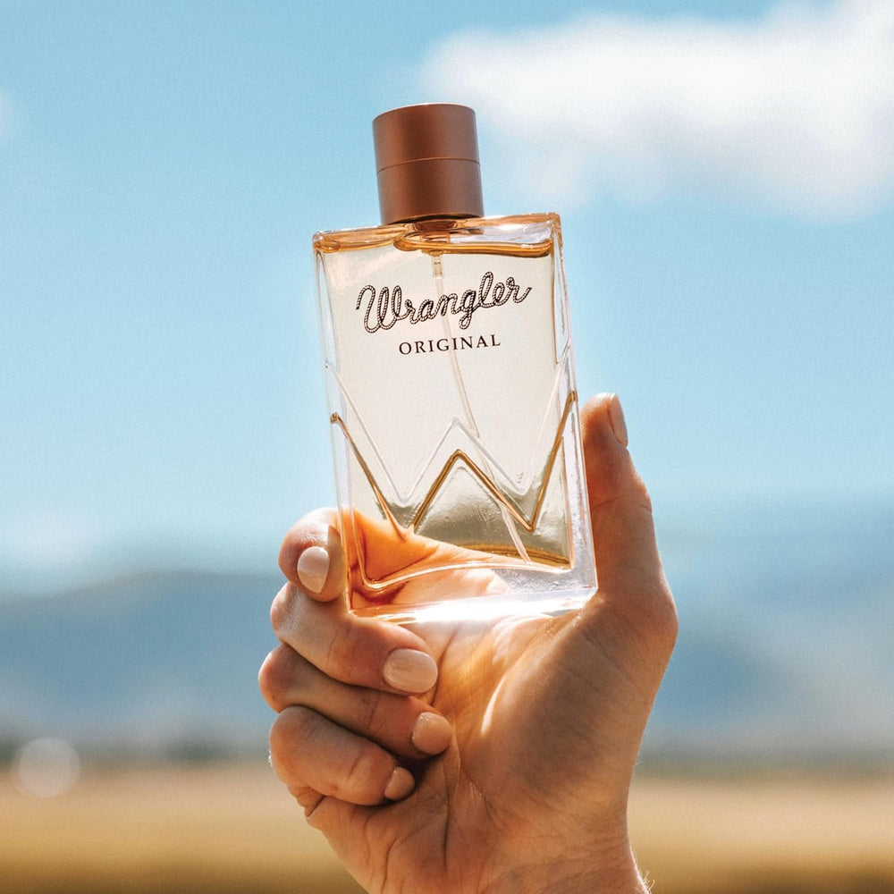 
                  
                    Woman Holding Bottle of Wrangler Original Perfume For Her by Tru Western
                  
                