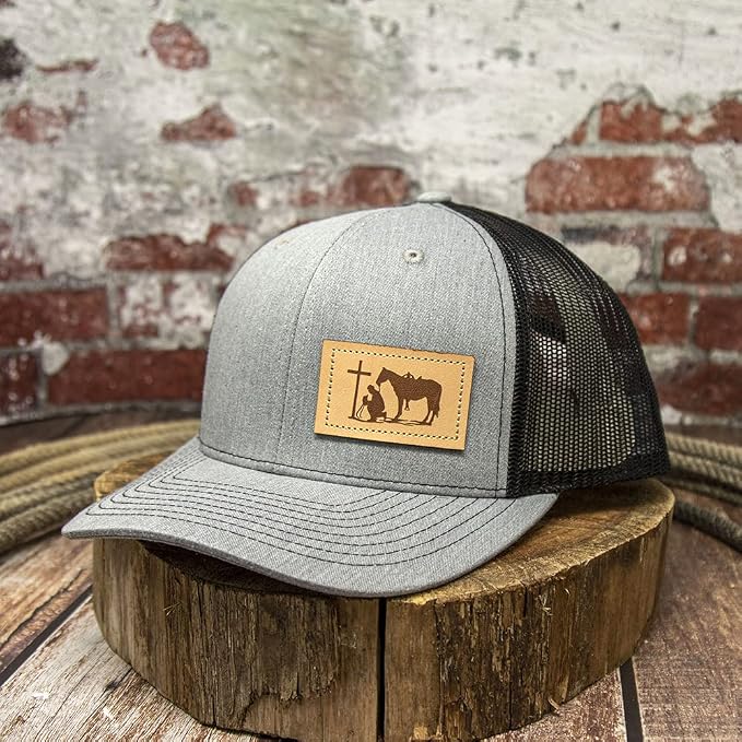 Richardson 310 trucker hat featuring a Cowboy Prayer leather patch in heather gray and black with an adjustable snapback closure.