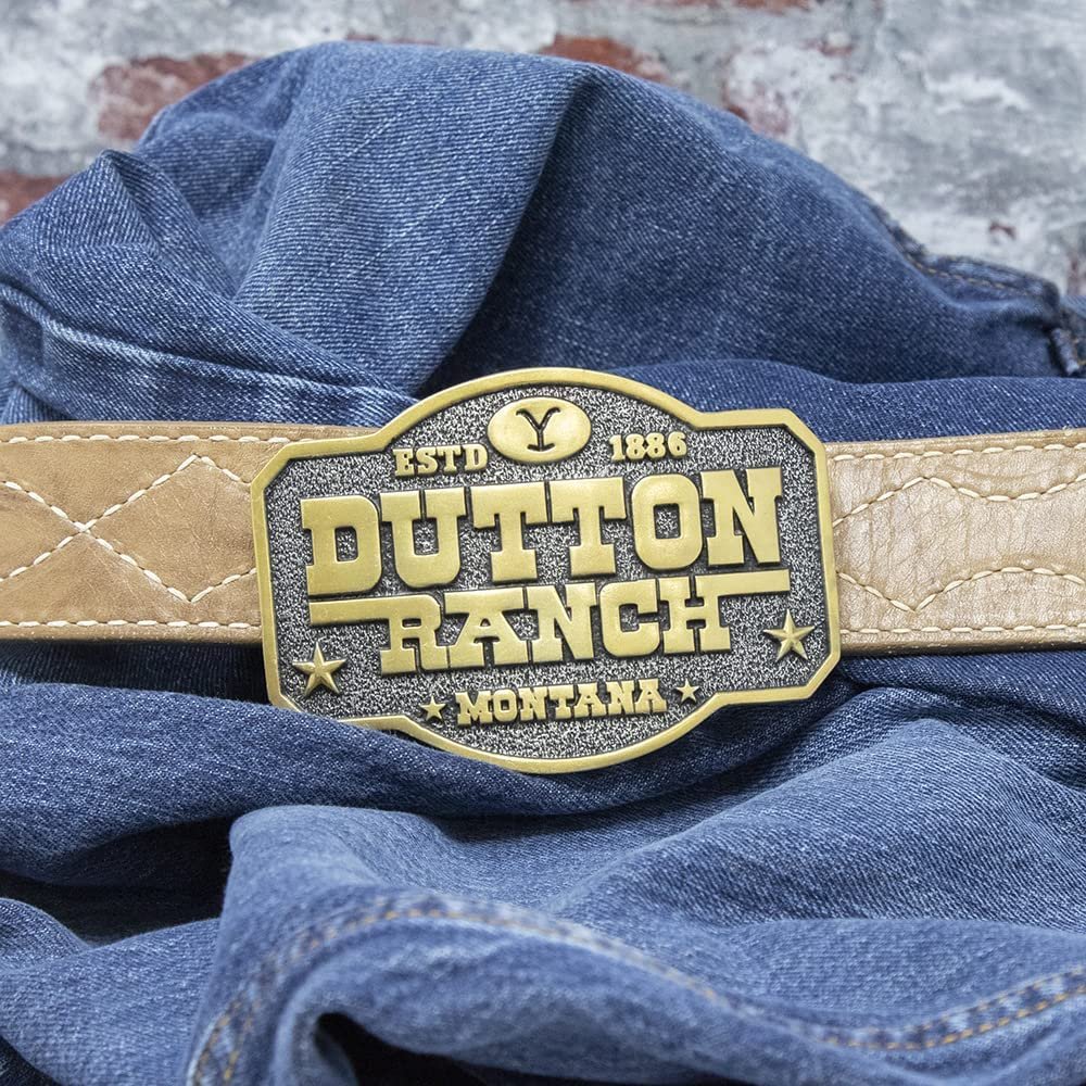 
                  
                    Montana Silversmiths x Yellowstone Collection Belt Buckle, With Dutton Ranch Montana Engraving Against Belt and Denim Fabric Background
                  
                